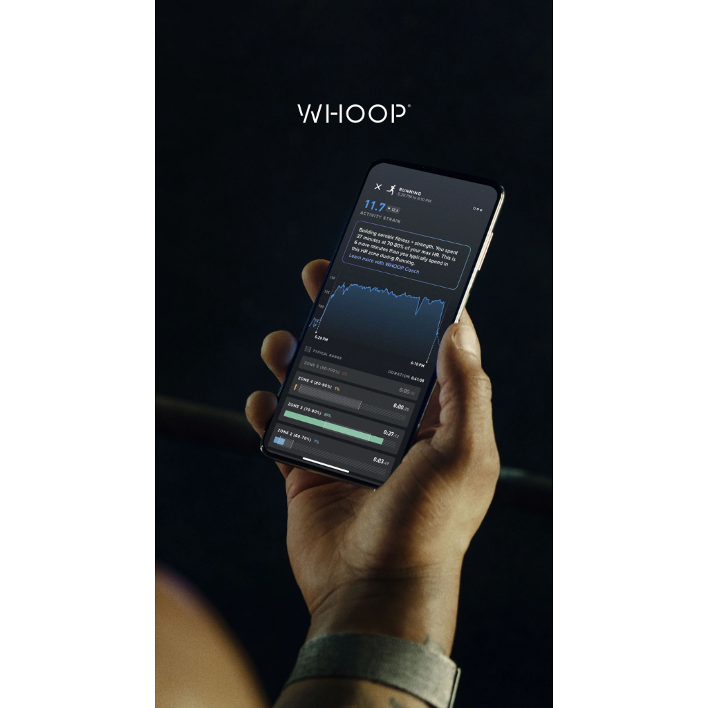 A hand holding a smartphone displaying WHOOP app data with a blue graph, set against a dark background with the brand name WHOOP above it - Bikers.SG