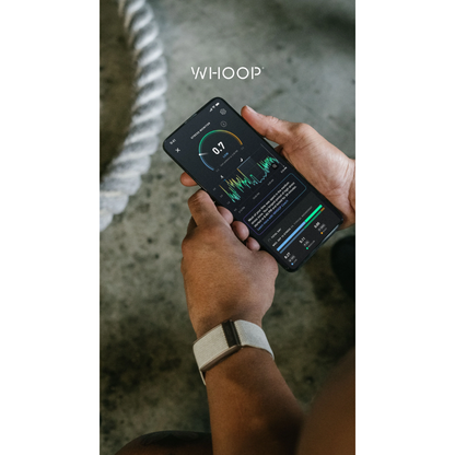 A person holding a smartphone showing the WHOOP fitness app screen, with a white WHOOP Peak 5.0 on their wrist. The background is a textured gray concrete floor with a white rope - Bikers.SG